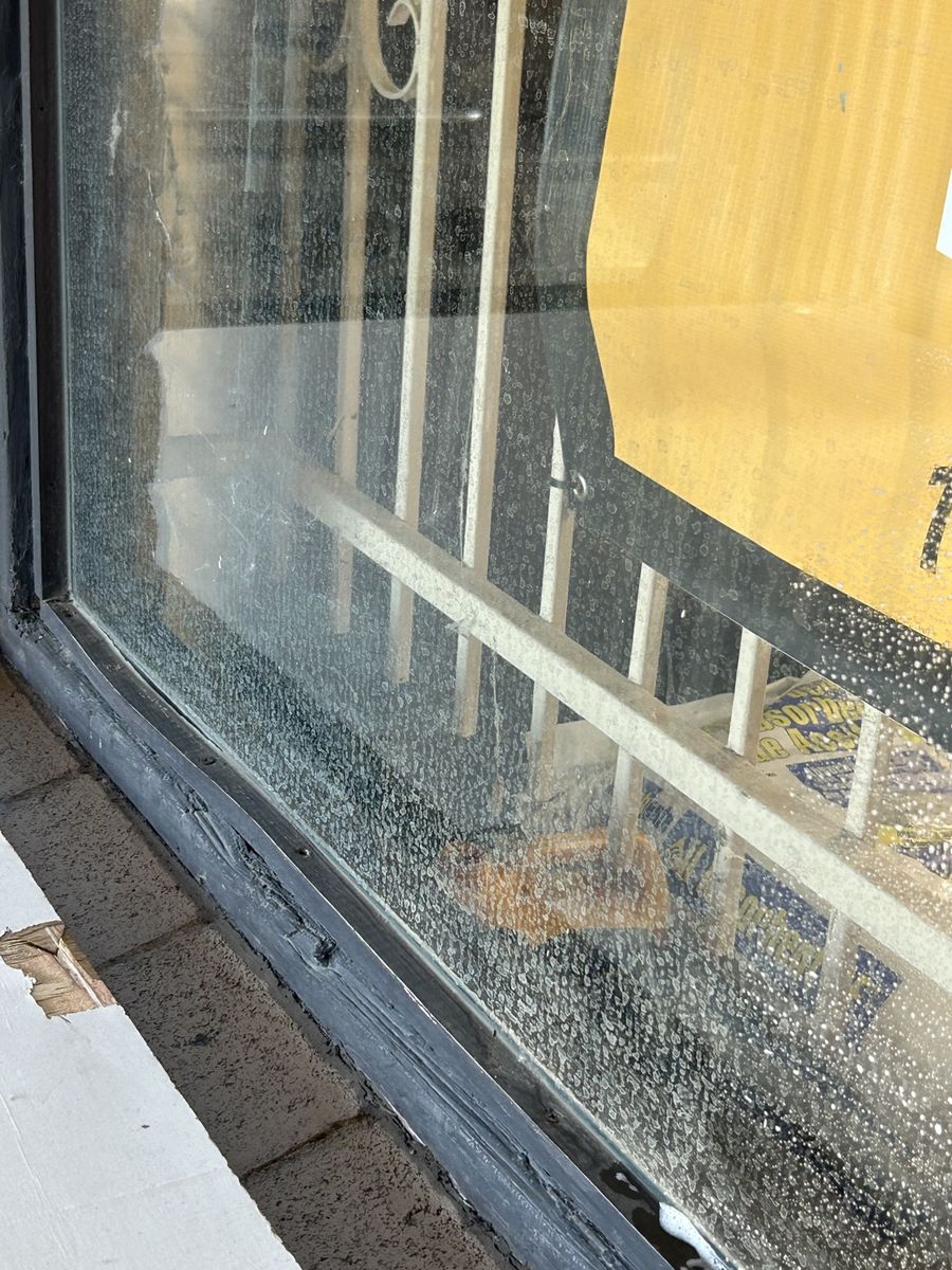 Water-spotted storefront glass before cleaning